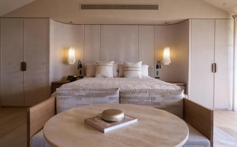 Une chambre lumineuse avec un grand lit et des tables de chevet.
