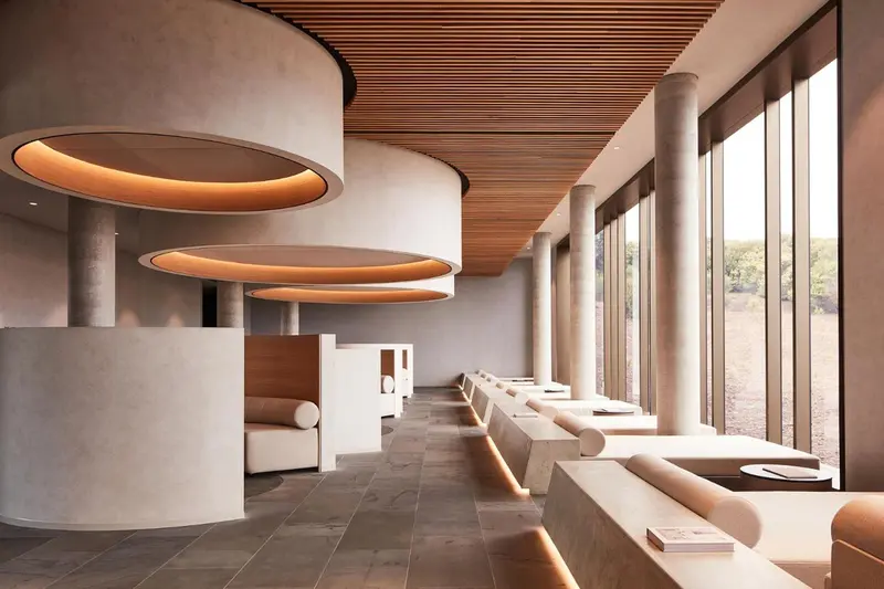 Espace intérieur lumineux avec des assises courbes et une grande baie vitrée.