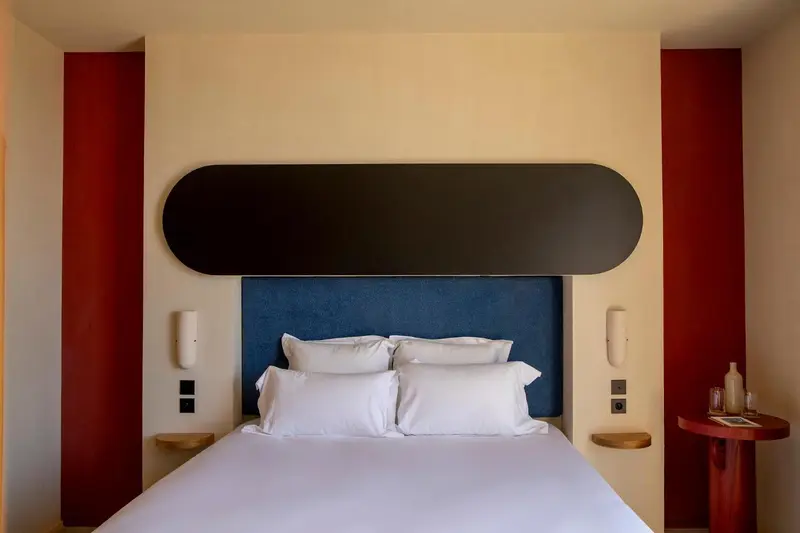 Un lit blanc avec des oreillers moelleux dans une chambre aux murs bicolores.