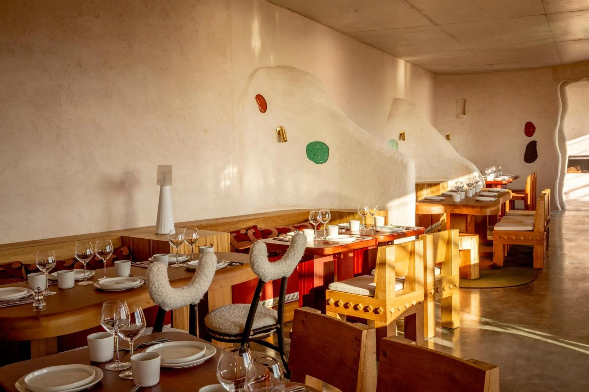 Une salle à manger lumineuse avec des tables dressées et des chaises en bois.