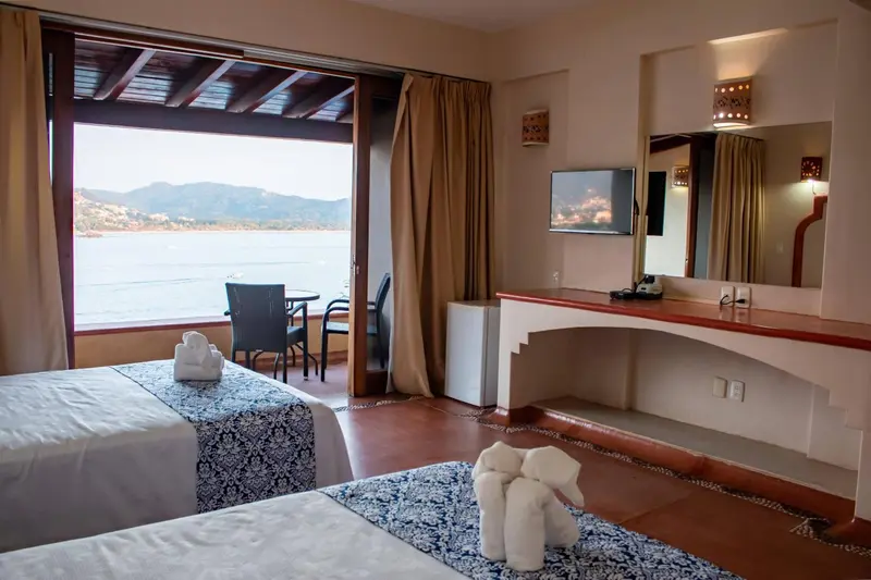 Chambre avec vue sur la mer et un coin repas sur le balcon.