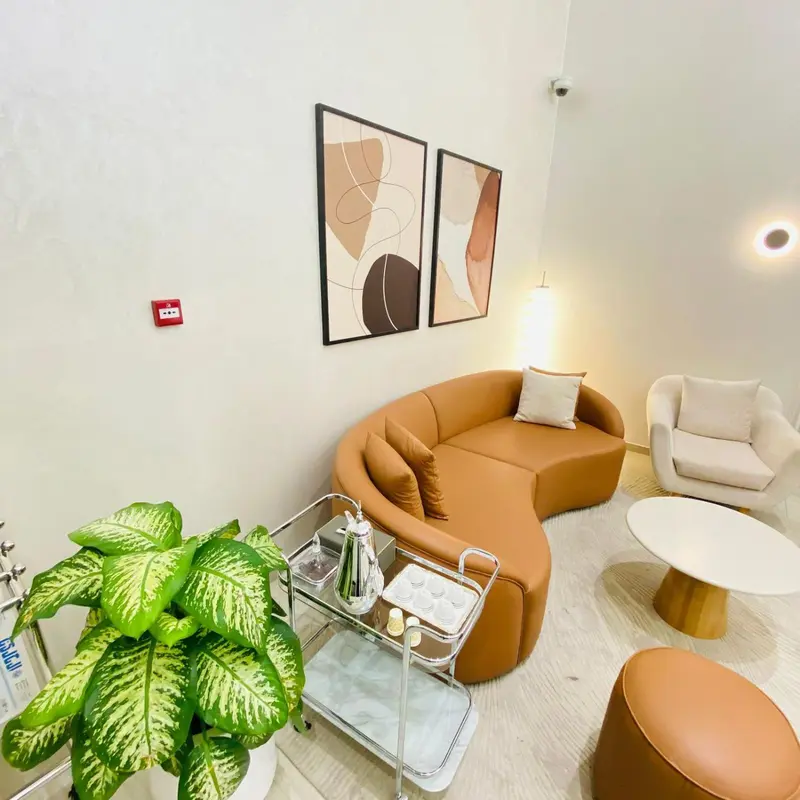 Un espace de détente avec un canapé incurvé et des fauteuils.