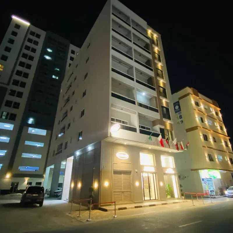 Façade d'un bâtiment moderne éclairée la nuit.