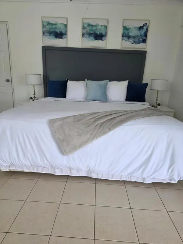 Une chambre lumineuse avec un grand lit recouvert d'une couverture.