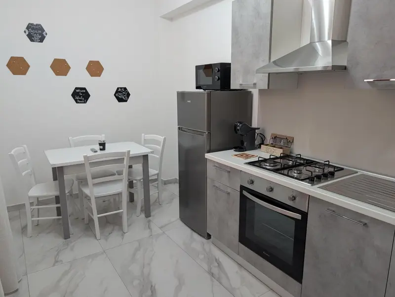 Une petite cuisine avec une table et des chaises.
