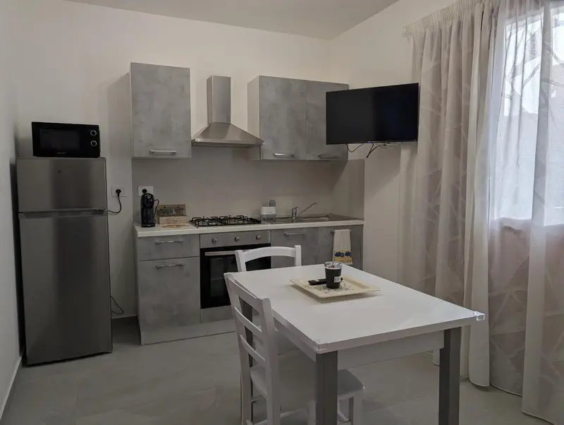 Une cuisine moderne avec un réfrigérateur, un micro-ondes et une table à manger.