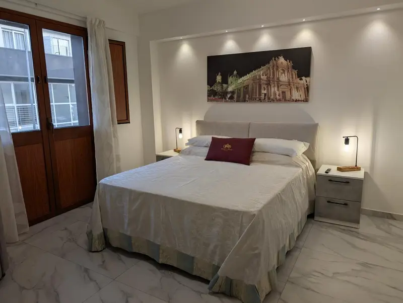 Une chambre lumineuse avec un grand lit et une décoration murale.