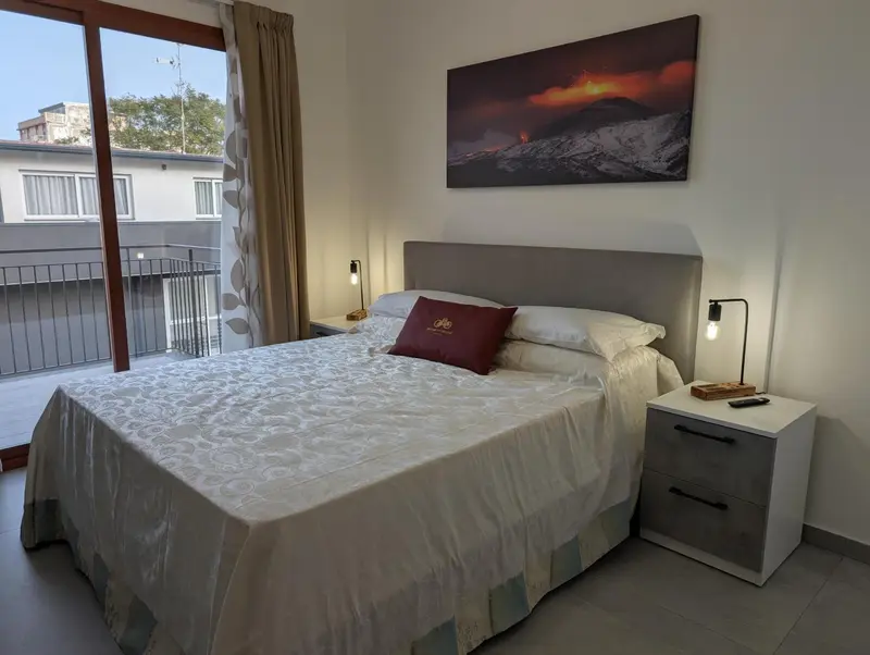 Une chambre lumineuse avec un grand lit et un tableau décoratif.