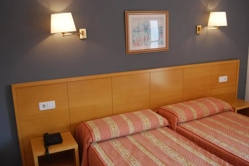 Une chambre avec un grand lit et des lampes murales.