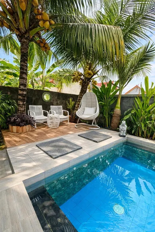 Espace de détente extérieur avec piscine et mobilier de jardin.