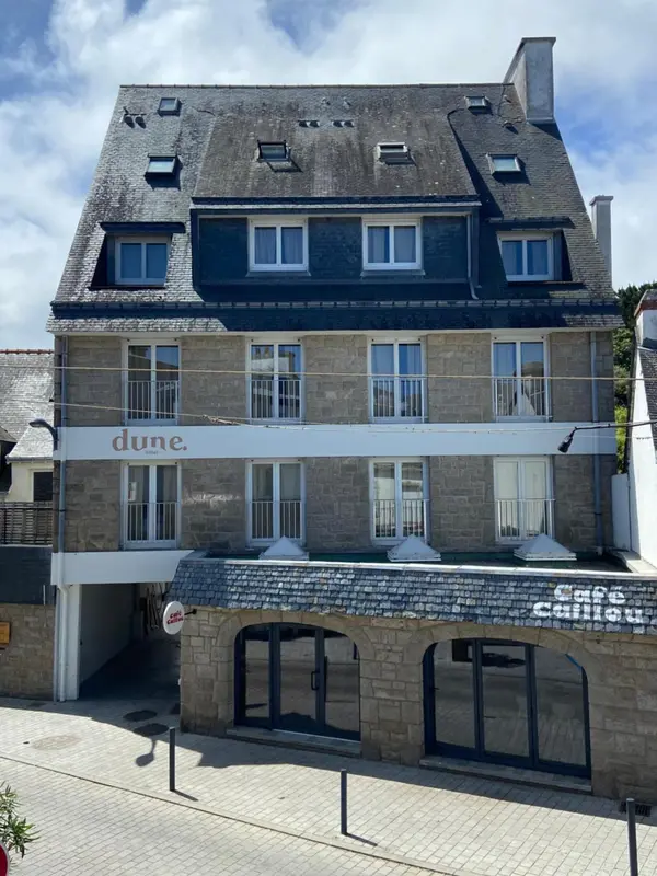 Façade d'un bâtiment en pierre avec des fenêtres et une devanture commerciale.