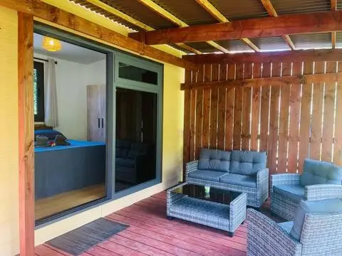Terrasse aménagée avec un salon de jardin et vue sur un espace intérieur.
