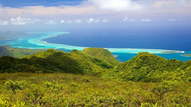 Vue panoramique sur une côte montagneuse et une lagune turquoise.