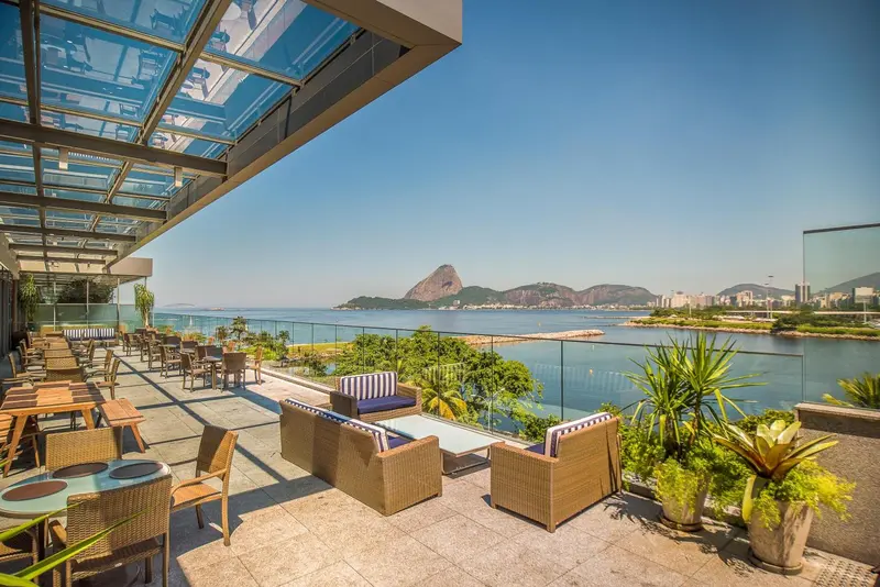 Terrasse aménagée avec mobilier de jardin et vue sur la mer.