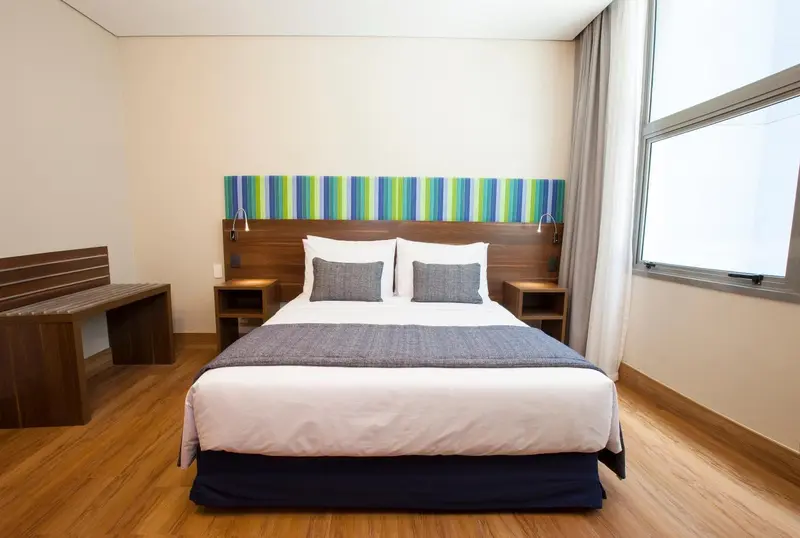 Une chambre lumineuse avec un grand lit et une décoration colorée.