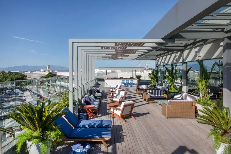 Terrasse aménagée avec mobilier de détente et vue sur la ville.