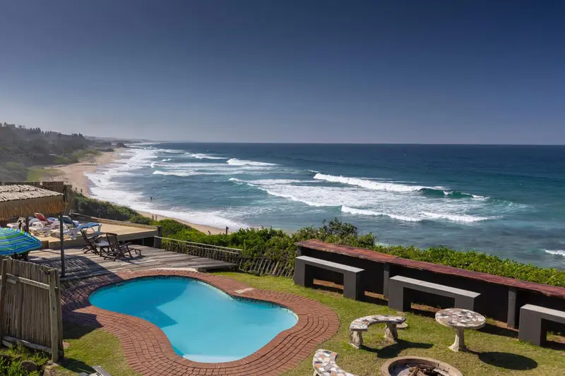 Une piscine avec une vue sur la mer et une plage.