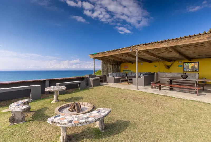 Espace extérieur aménagé avec des tables basses et des canapés face à la mer.