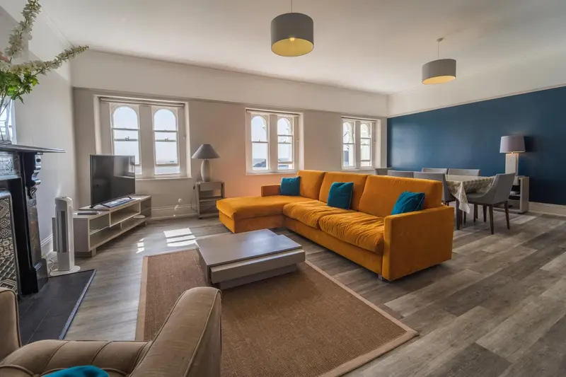 Un salon lumineux avec un canapé d'angle et une table basse.