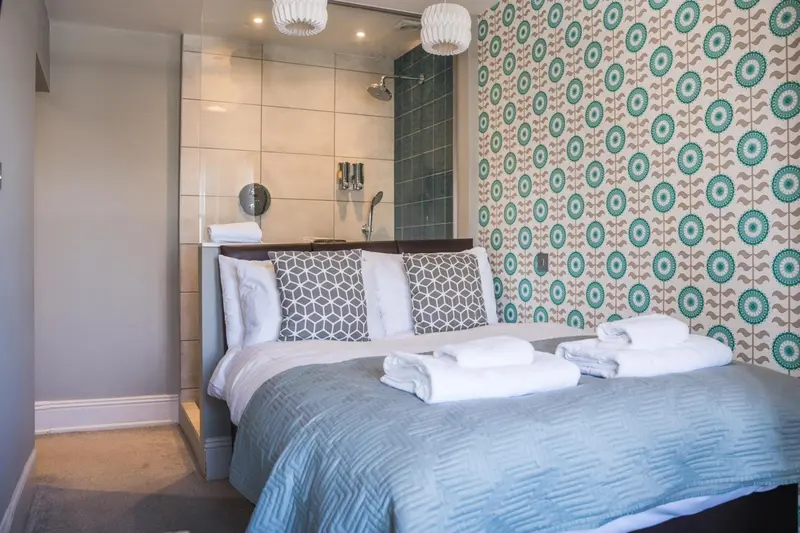 Une chambre avec un grand lit et une douche à l'italienne.