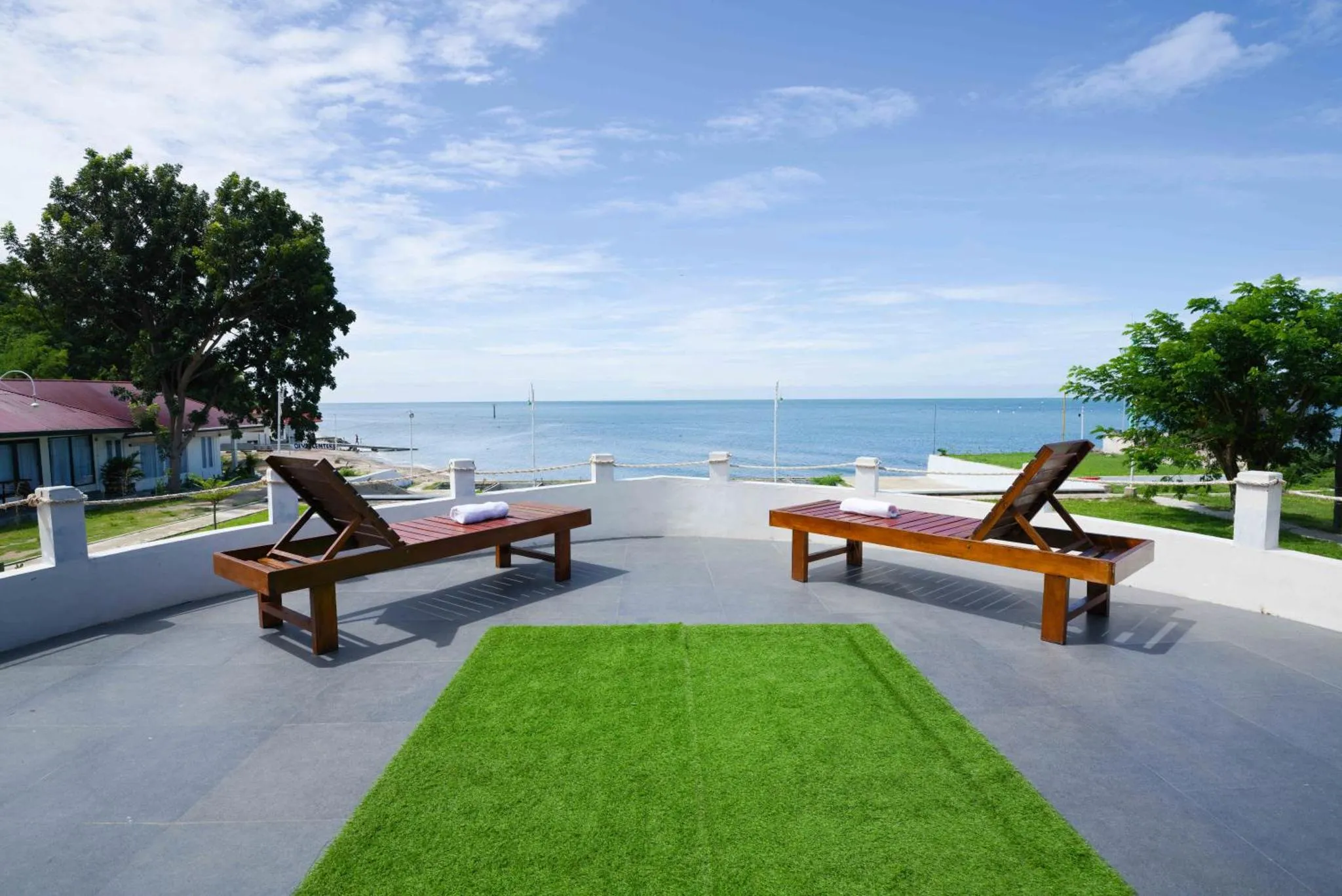 Transats alignés sur une terrasse surplombant la mer.