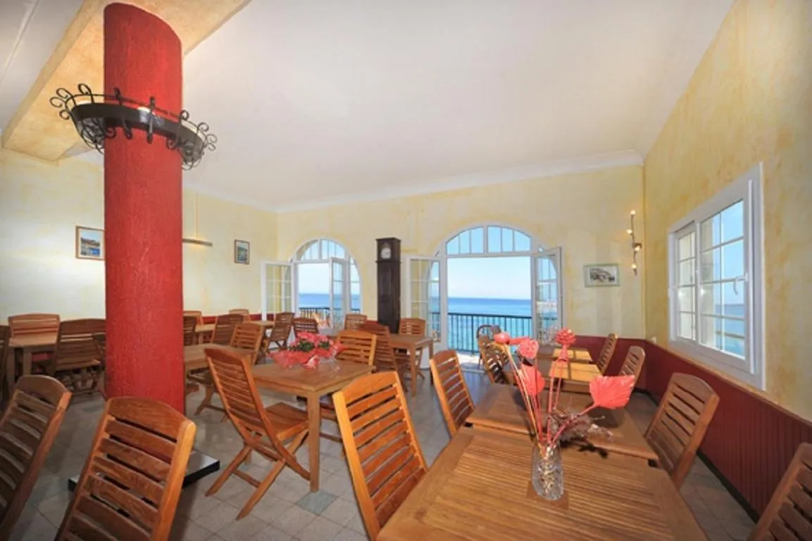 Une salle lumineuse avec des tables et des chaises disposées pour les repas.