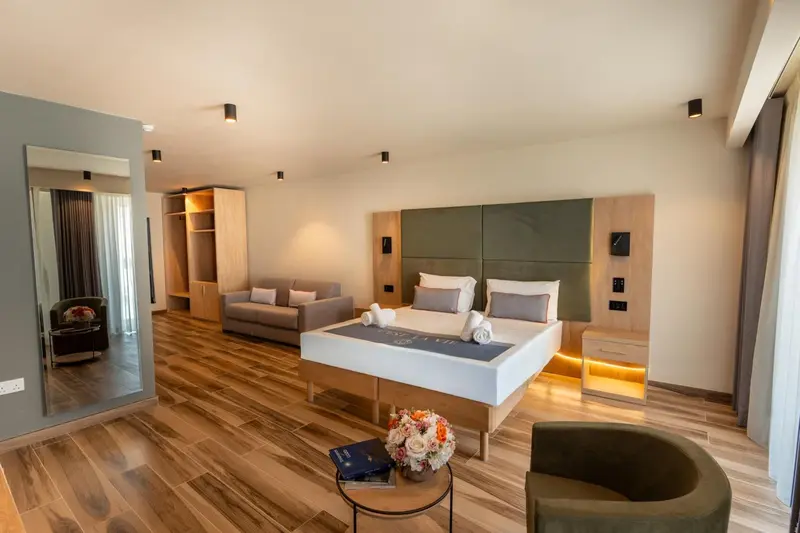 Une chambre spacieuse avec un grand lit et un coin salon.