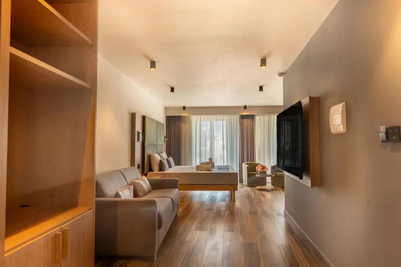 Espace de vie lumineux avec canapé et lit.
