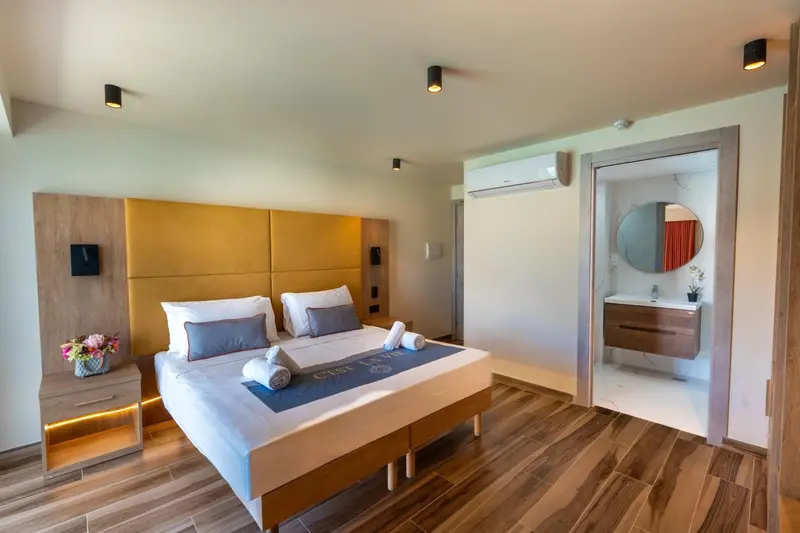 Une chambre lumineuse avec un grand lit et un accès à une salle de bain.