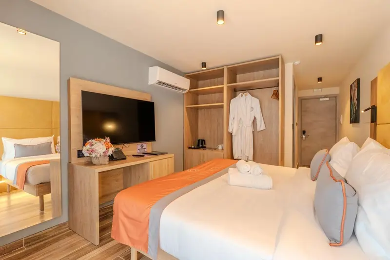 Une chambre lumineuse avec un grand lit et un bureau.