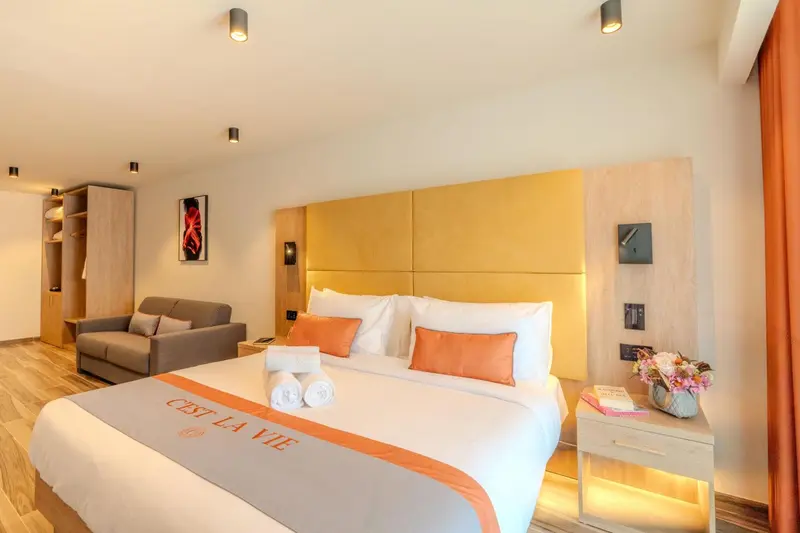 Une chambre lumineuse avec un grand lit et un canapé.