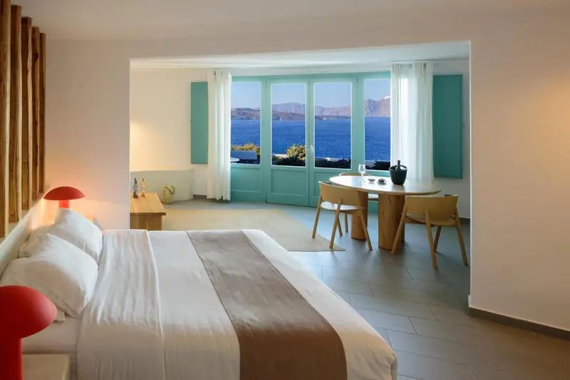 Une chambre lumineuse s'ouvre sur une vue mer à travers de larges baies.