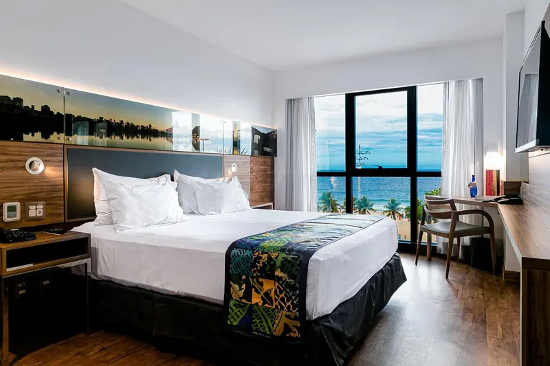 Une chambre lumineuse avec un grand lit et une vue sur la mer.