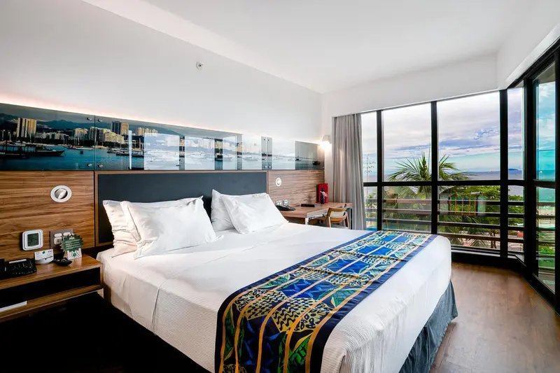 Une chambre lumineuse avec un grand lit et une vue sur la mer.