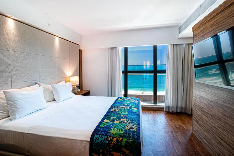 Une chambre lumineuse avec un grand lit donnant sur l'océan.