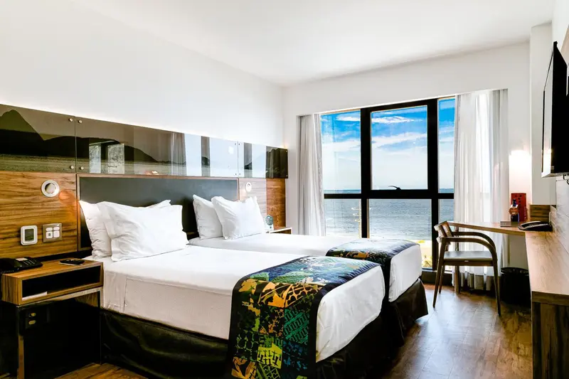 Une chambre lumineuse avec un grand lit et une vue sur la mer.