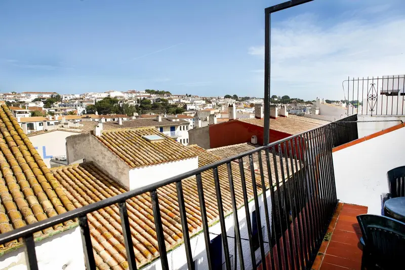 Vue d'une ville depuis un balcon avec garde-corps en métal.