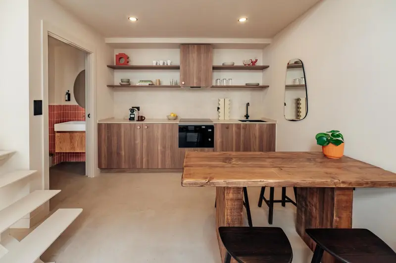 Une cuisine moderne avec un plan de travail en bois et des étagères murales.