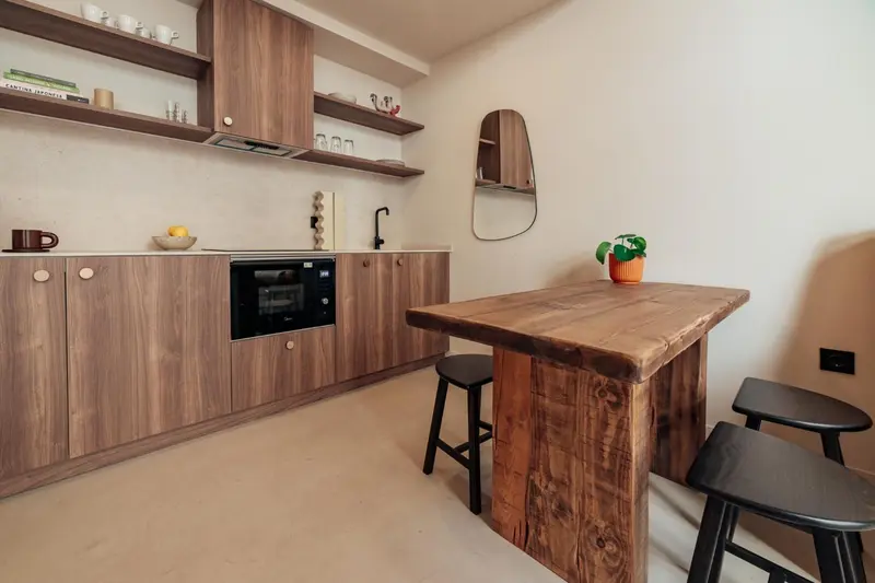 Une cuisine moderne avec un plan de travail en bois et des tabourets hauts.