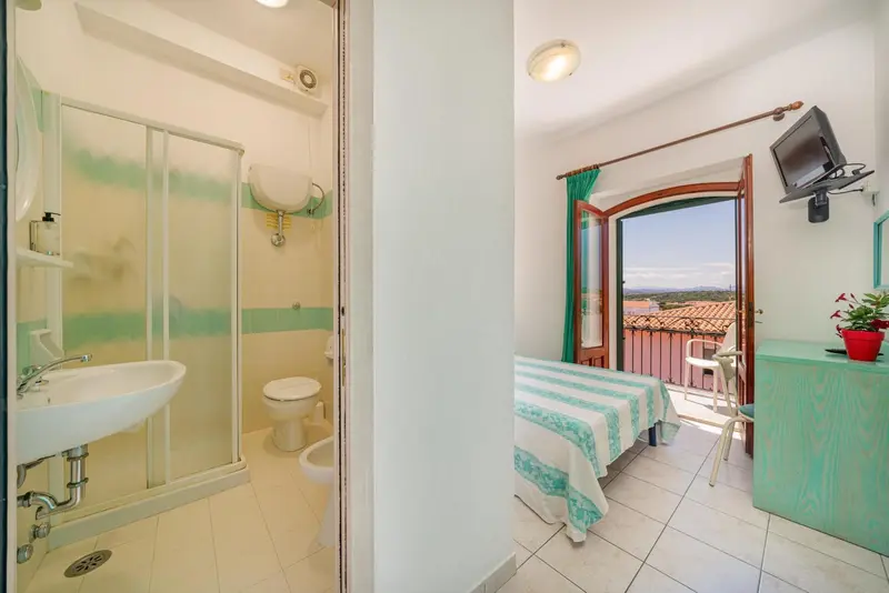 Une salle de bain et une chambre avec balcon sont visibles.