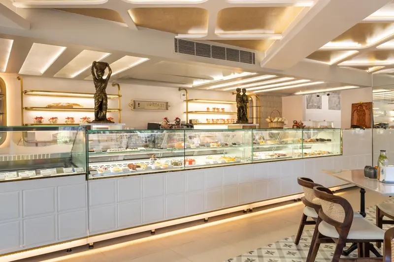 Présentoir réfrigéré rempli de pâtisseries dans un espace lumineux et moderne.