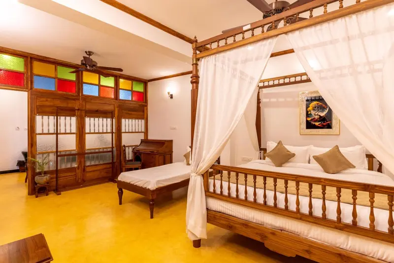 Une chambre lumineuse avec un grand lit à baldaquin en bois.