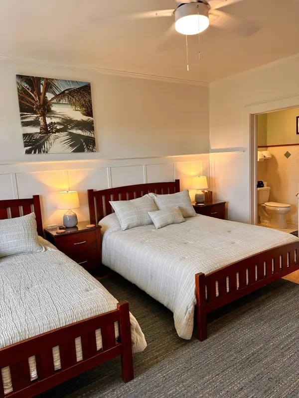 Une chambre avec deux lits et une salle de bain attenante.