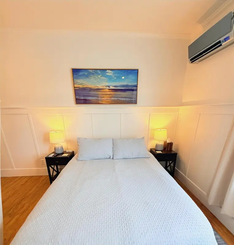 Une chambre lumineuse avec un grand lit et des lampes de chevet.