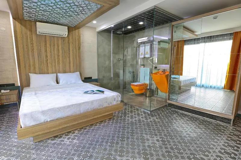 Chambre moderne avec un grand lit et une douche à l'italienne vitrée.