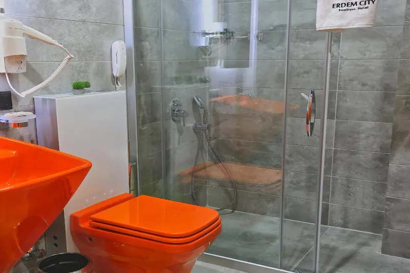 Une salle de bain moderne avec douche à l'italienne et sanitaires colorés.