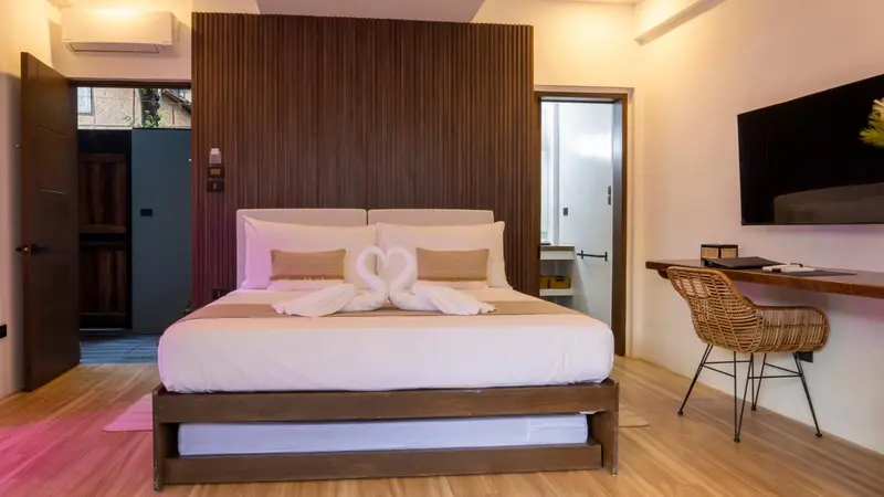 Une chambre lumineuse avec un grand lit et un espace bureau.