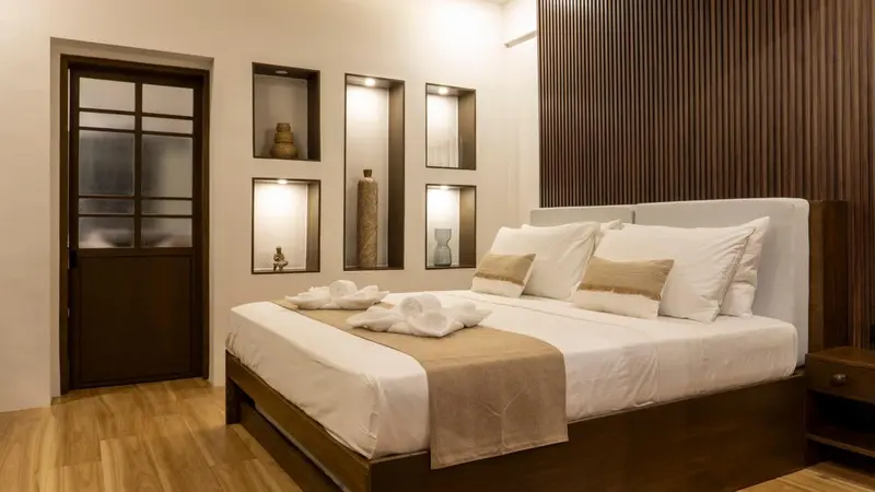 Une chambre lumineuse avec un grand lit recouvert de coussins et de serviettes.