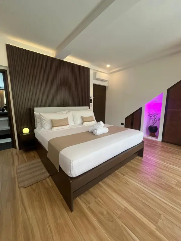 Une chambre lumineuse avec un grand lit et une décoration moderne.