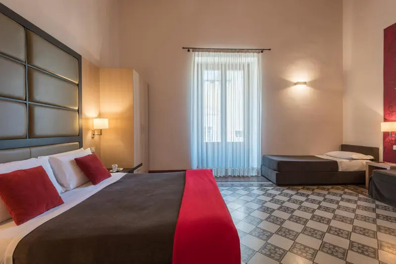 Une chambre lumineuse avec deux lits et un carrelage décoratif.